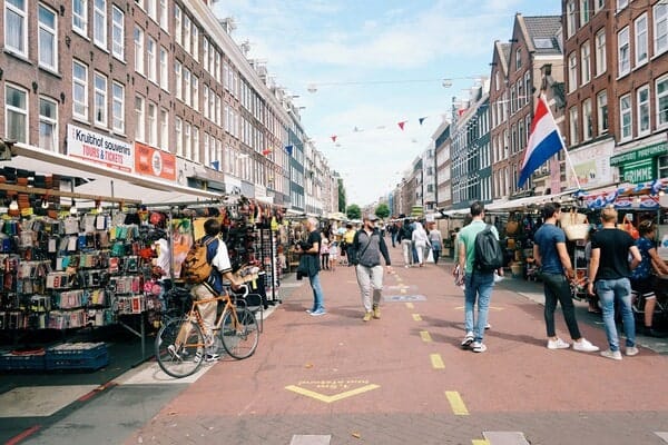 outdoor market with people walking past stalls
