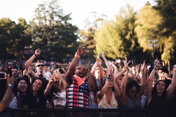 People at a festival with their hands raised in the air