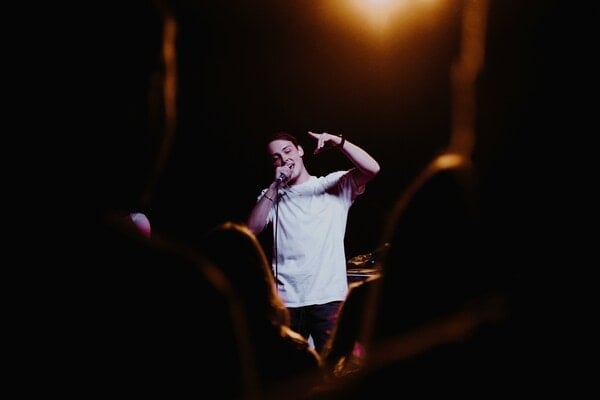 Man performing on stage at a comedy show.