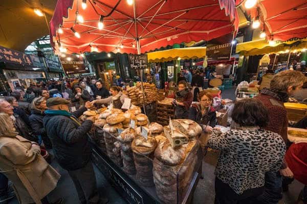 people gathered around a food stall at a food market in London