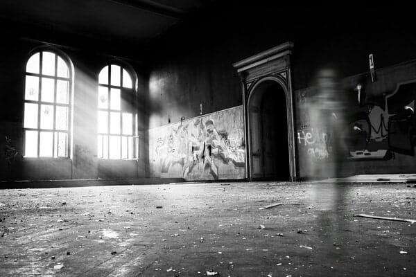 Empty, abandoned building with blurred image of a ghost.