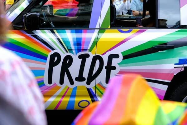 Car decorated in pride colours and the word "pride" in the centre