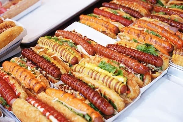 Multiple hot dogs with sauce drizzled all over them