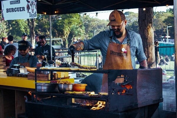Man flipping burgers at a food stall