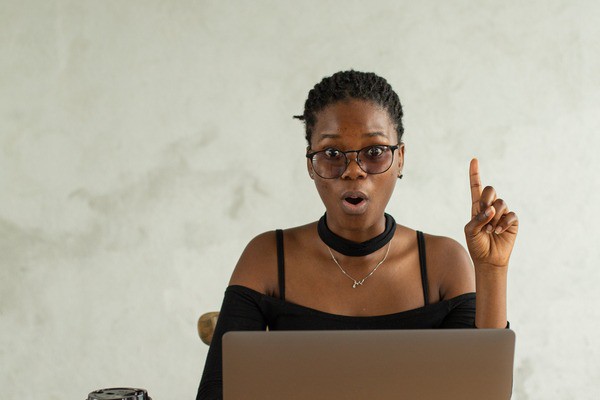 someone using a laptop, posing a question towards a situation