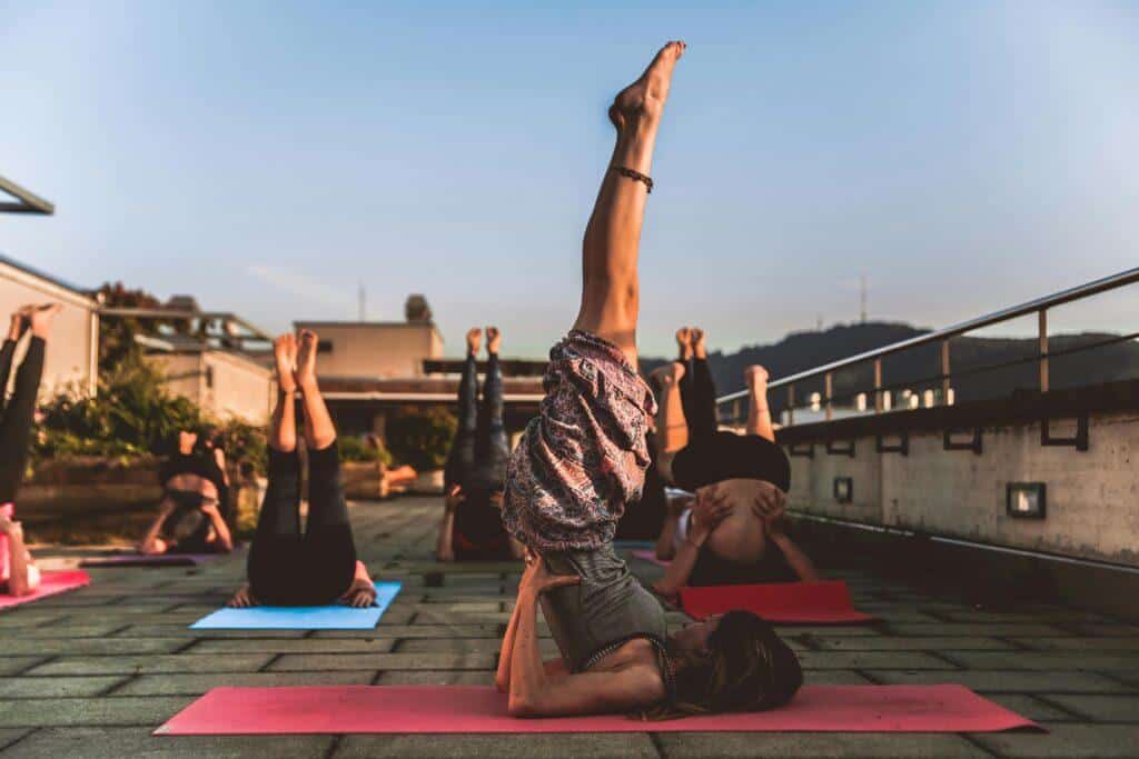 Young people practicing outdoor yoga on a rooftop 