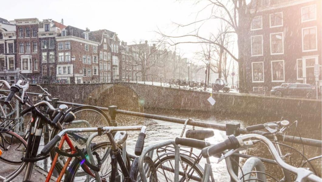 bikes on a canal in the rain in amsterdam