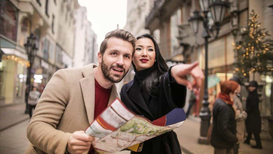 Women directing a man a man holding a map.