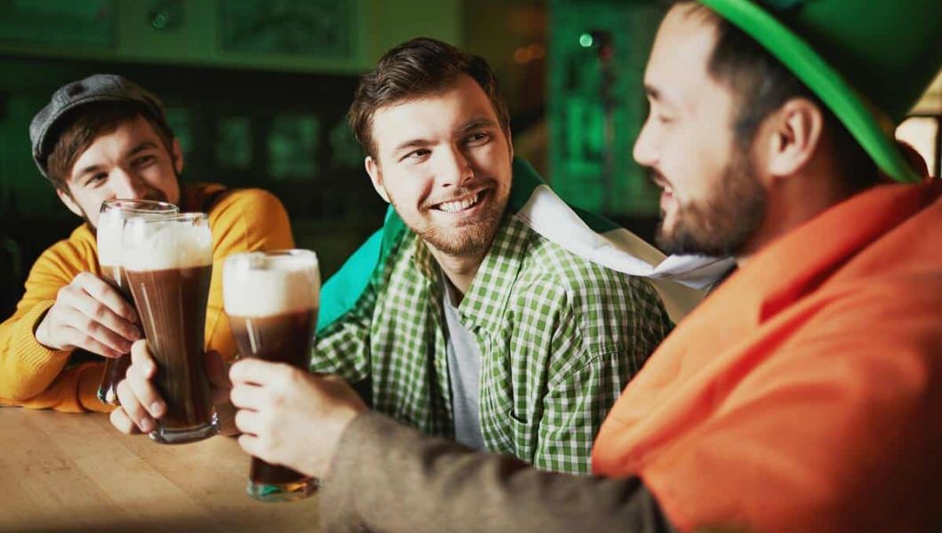 3 men in a pub drinking beer and celebrating St. Patrick's Day
