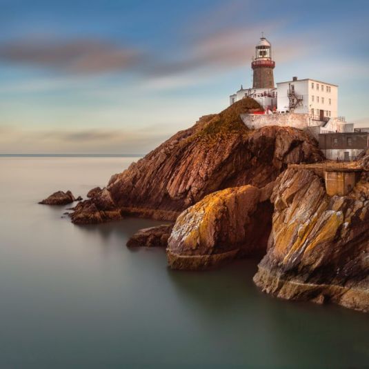 Dublins berühmter Stadtteil Howth mit Blick auf das Meer und einem Leuchtturm auf der Klippe 